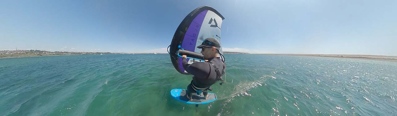 Wingfoiler from back mount riding across Portland Harbour